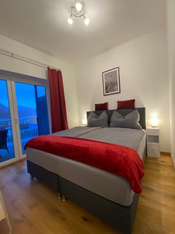 格蒙登CityLake G23 Apartments的一间卧室配有一张带红色毯子的大床