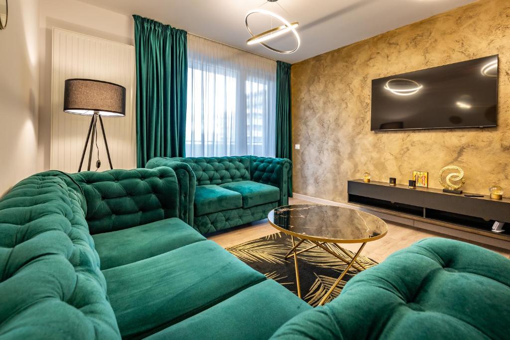 布拉索夫Carpatilor Apart Hotel Brasov的客厅配有绿色沙发和桌子