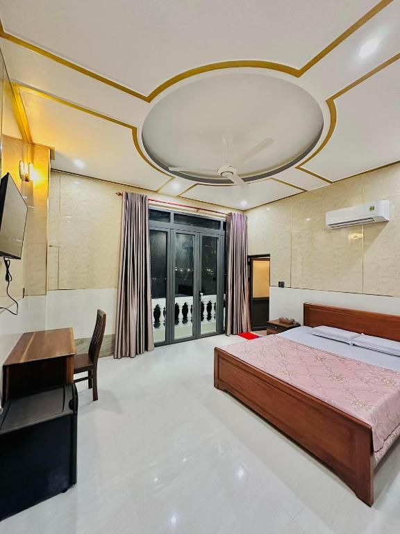 龙川市Golden Hotel的大型客房配有床、书桌和电视。