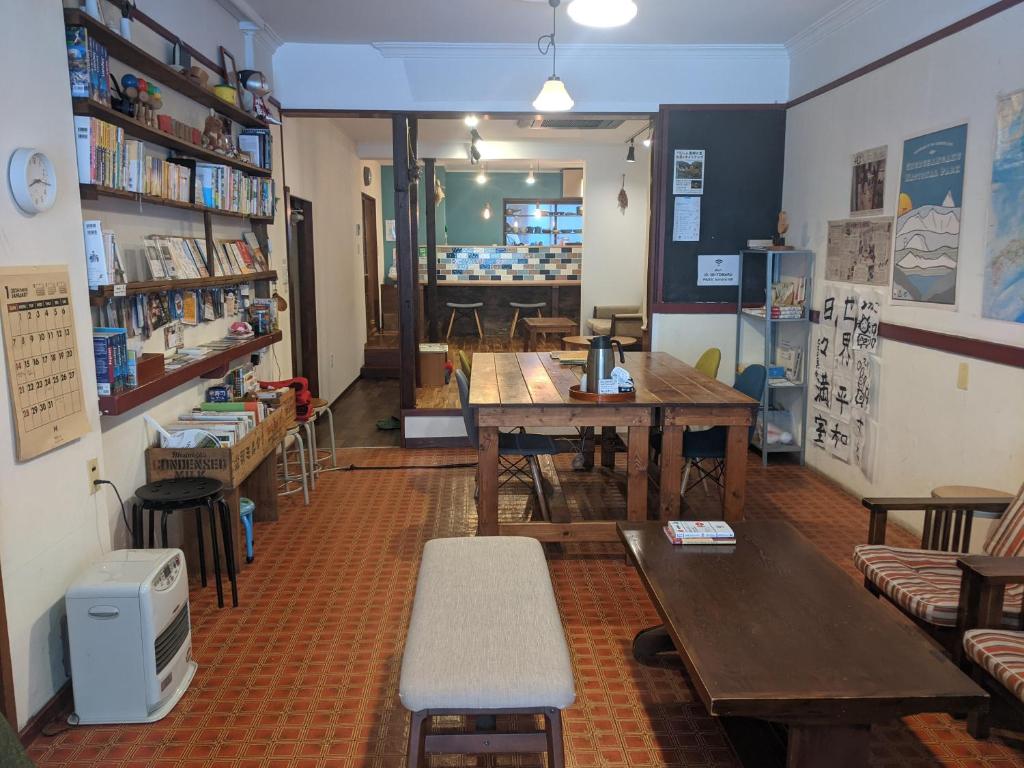 高山Guesthouse Tomaru的书店内带桌子和长凳的房间