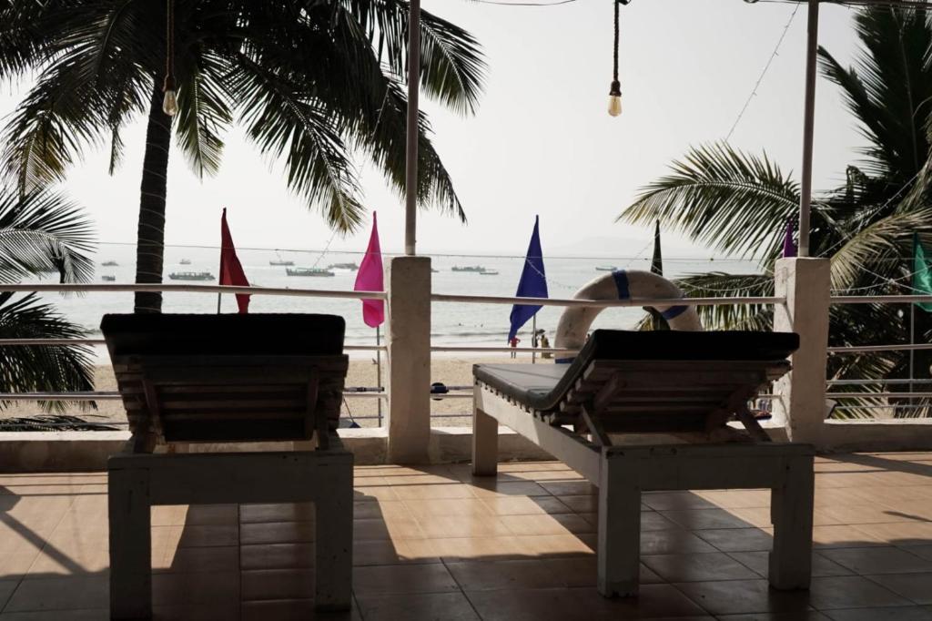 波戈马洛Saritas Guest House - Bogmalo Beach的坐在长凳上,看着海滩的人