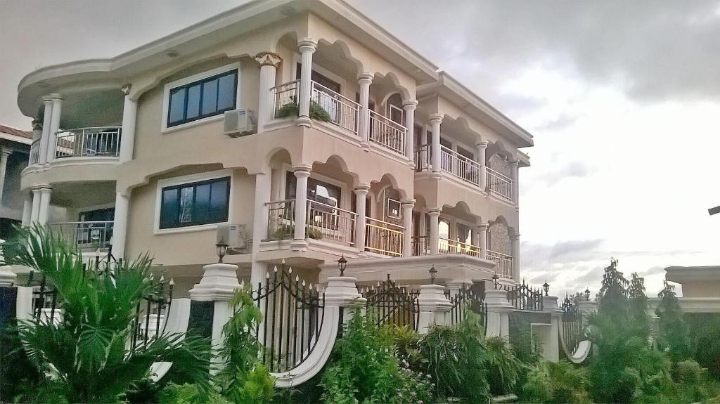 GoderichMAYRAH Inn - Your comfortable home from home in Freetown Sierra Leone的一座大型白色建筑,设有阳台