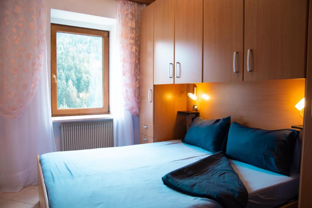 莫尔韦诺Residenza Garibaldi的一间卧室配有一张带蓝色枕头的床和一扇窗户。