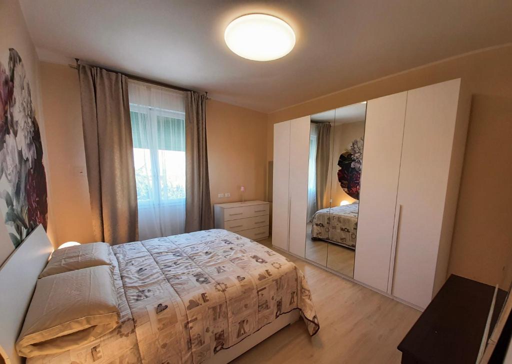 雷诺河畔卡萨莱基奥EDC home con parcheggio e self check in的一间卧室配有一张床和一面大镜子