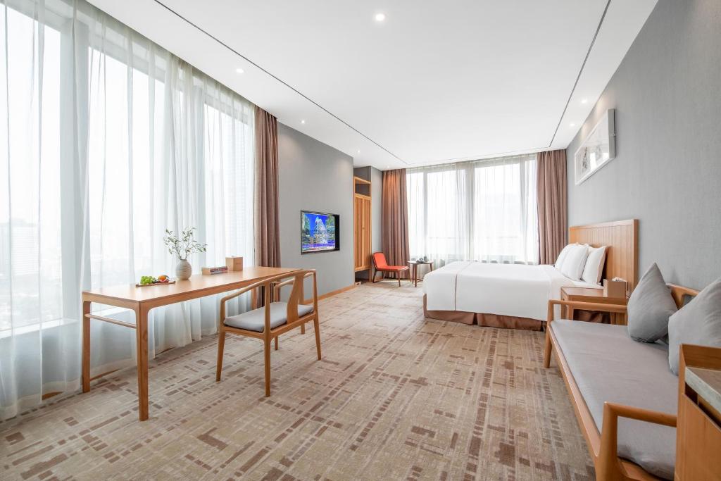 广州广州珠江新城华轩里酒店的配有一张床和一张书桌的酒店客房