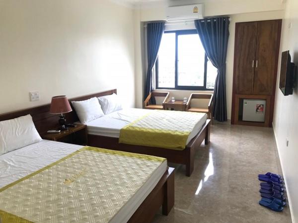 格卢市社Khách sạn Sơn Hiền Cửa Lò的酒店客房设有两张床和窗户。