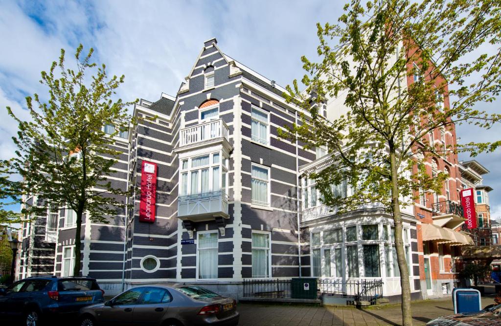 阿姆斯特丹阿姆斯特丹市中心莱昂纳多酒店的一座黑色和白色的建筑,上面有红色的标志