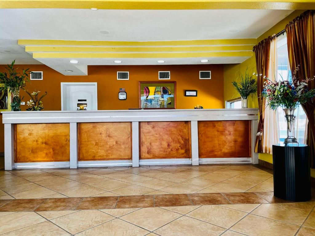 德尔里奥Econo Lodge Del Rio的酒店大堂的酒吧,拥有橙色的墙壁