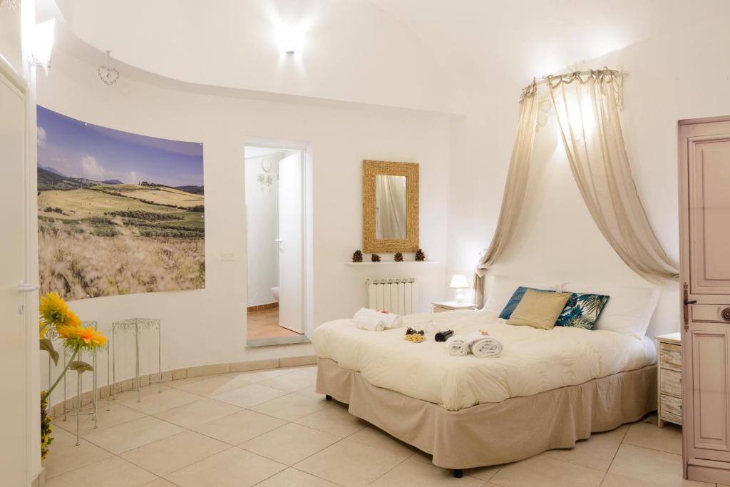 锡耶纳Casa Vezzosa的卧室配有一张大床,墙上挂有绘画作品