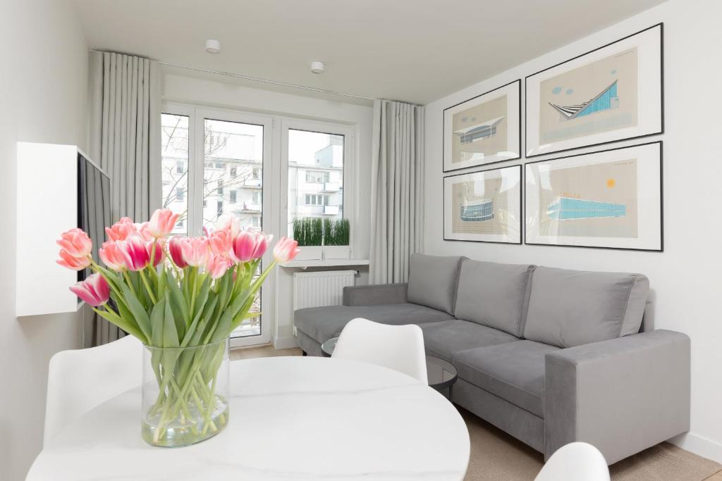 华沙Elegant & Cozy Apartment Pańska by Renters的客厅,桌子上放着一团粉红色的花