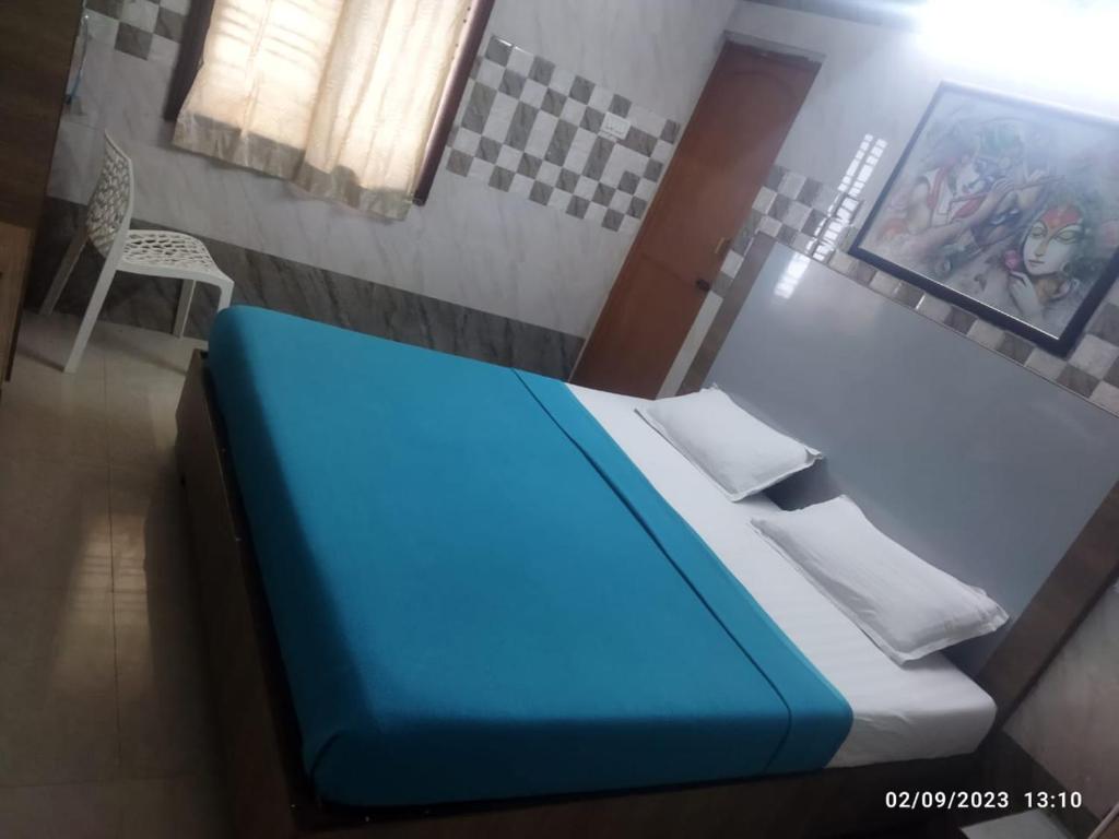 钦奈Surya's Guest House的一间小卧室,配有蓝色的床和椅子