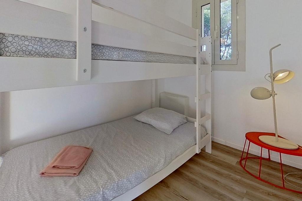 阿尔加约拉Résidences Sopramare的一间卧室配有双层床、桌子和台灯