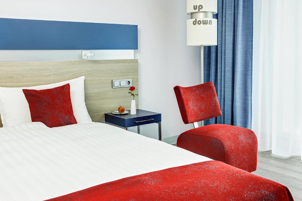 恩斯赫德恩斯赫德城际酒店的一间卧室配有一张床和一张红色椅子