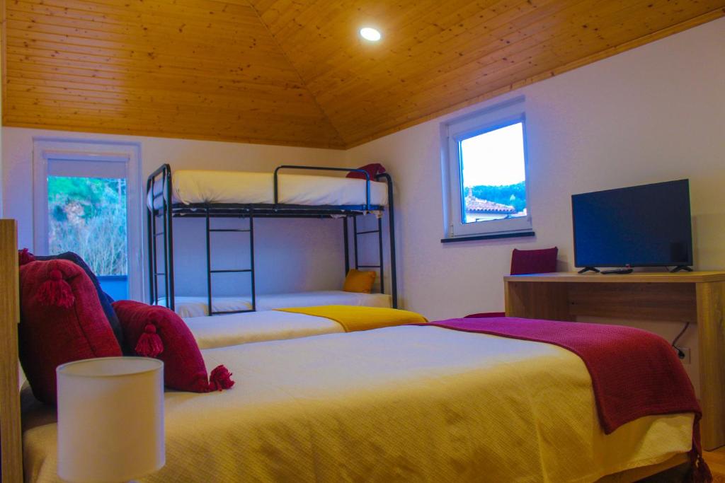 戈伊什Casa de Campo Vale do Ceira的一间卧室配有两张床和一台平面电视