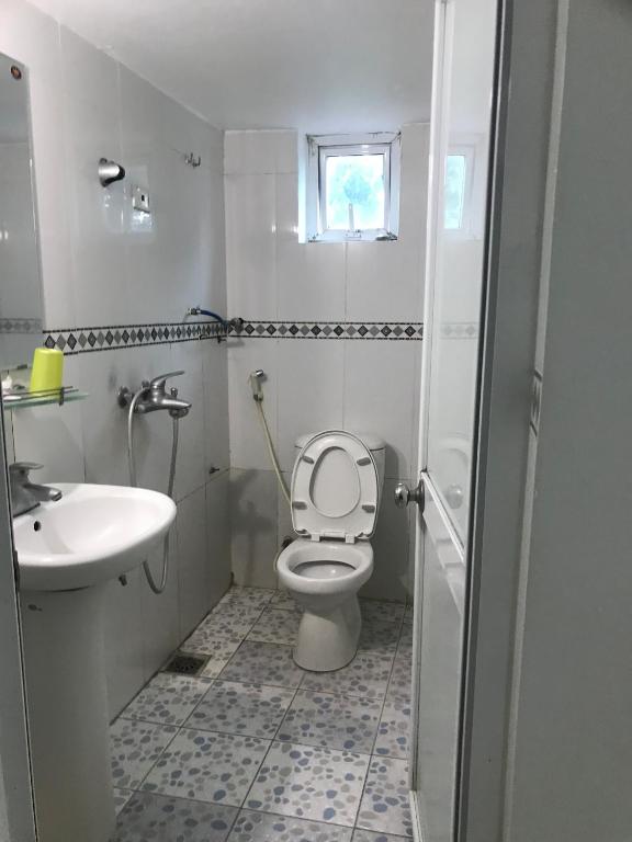 Sóc SơnHotel Thuý đông的白色的浴室设有卫生间和水槽。