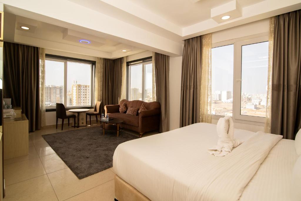 锡卜Diamond Star Hotel فندق النجمة الماسية的酒店客房设有床和客厅。