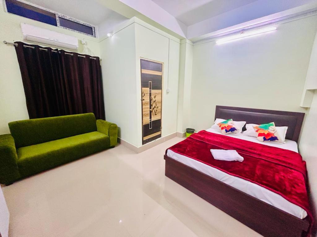 TezpurJM Suites的一间卧室配有一张床和一把绿色椅子