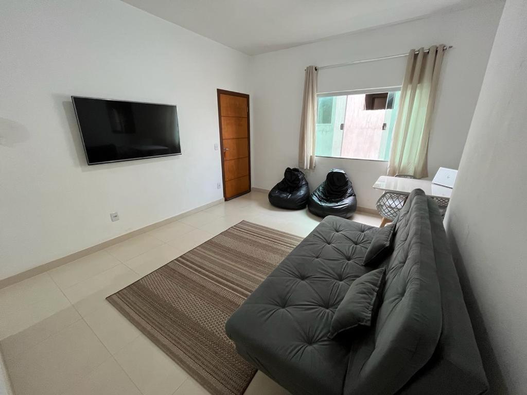卡皮托利乌Apartamento Aconchegante的带沙发和平面电视的客厅