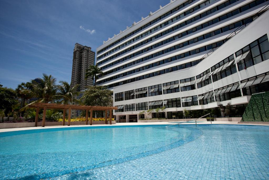 萨尔瓦多巴伊亚威什酒店的一座大建筑前的游泳池