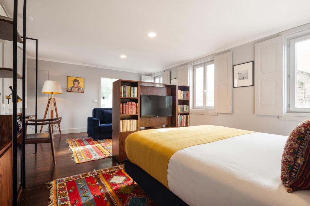 波尔图Utopian Hotel, a charming guesthouse的一间卧室配有一张床,并在一间客房内配有电视。