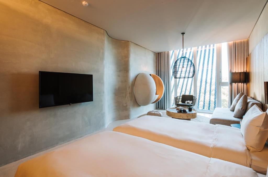 礁溪了了礁溪 Vivir Jiaoxi Hotel的酒店客房设有两张床和一台平面电视。