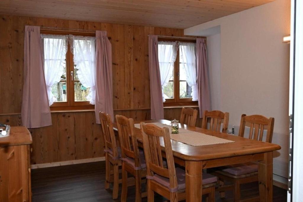 BütschwilBauernhof Sal的一间带木桌和椅子的用餐室