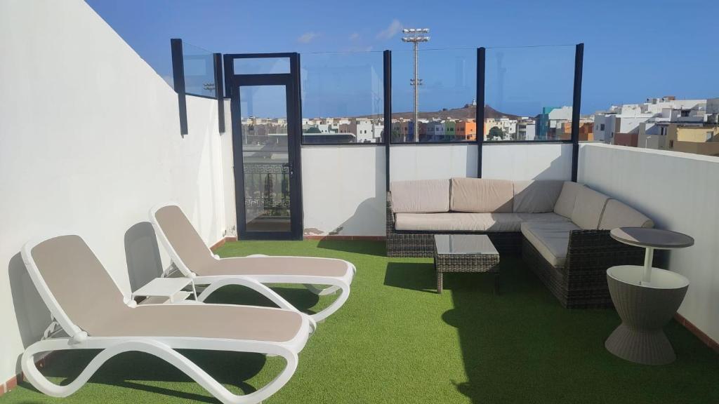 阿里纳加Apartamentos Risco Verde的阳台配有两把椅子和一张屋顶沙发。