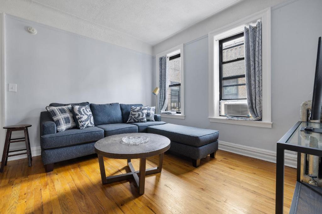 纽约Live Upper Manhattan on a Budget的客厅配有蓝色的沙发和桌子