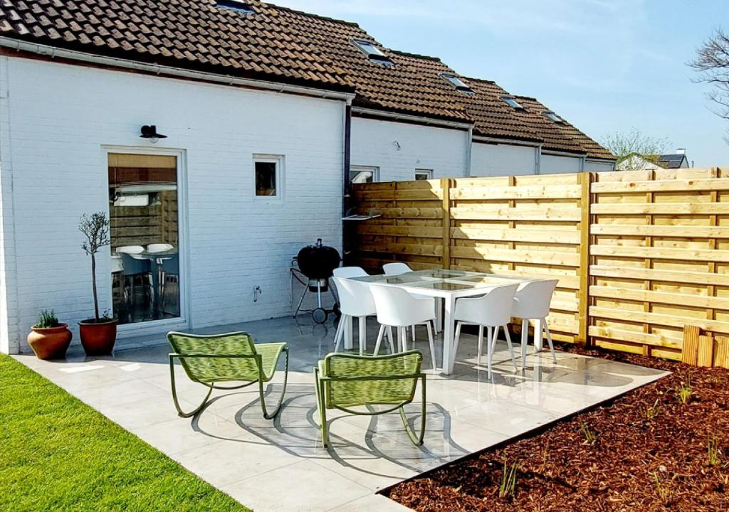 布列登Salty - Vakantiehuisje op de grens van Bredene-De Haan的一个带桌椅和围栏的庭院