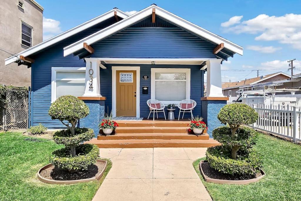 长滩Spacious Home Close to Downtown Long Beach & Convention Ctr的蓝色房子前面有两把椅子