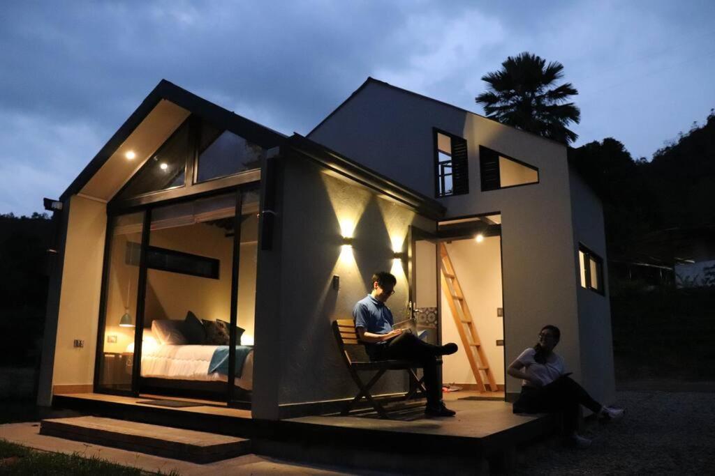 拉维加Luxury Glamping - Tiny House al natural的两人坐在一个小房子前面