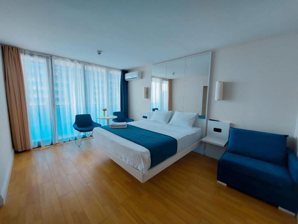 巴统Orbi city - Premium Class Rooms的一间卧室配有一张大床和一张蓝色椅子