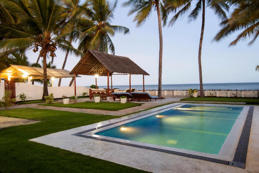 MsambweniOasys House - Beautiful Private Beach Front Home的一个带凉亭的游泳池以及大海