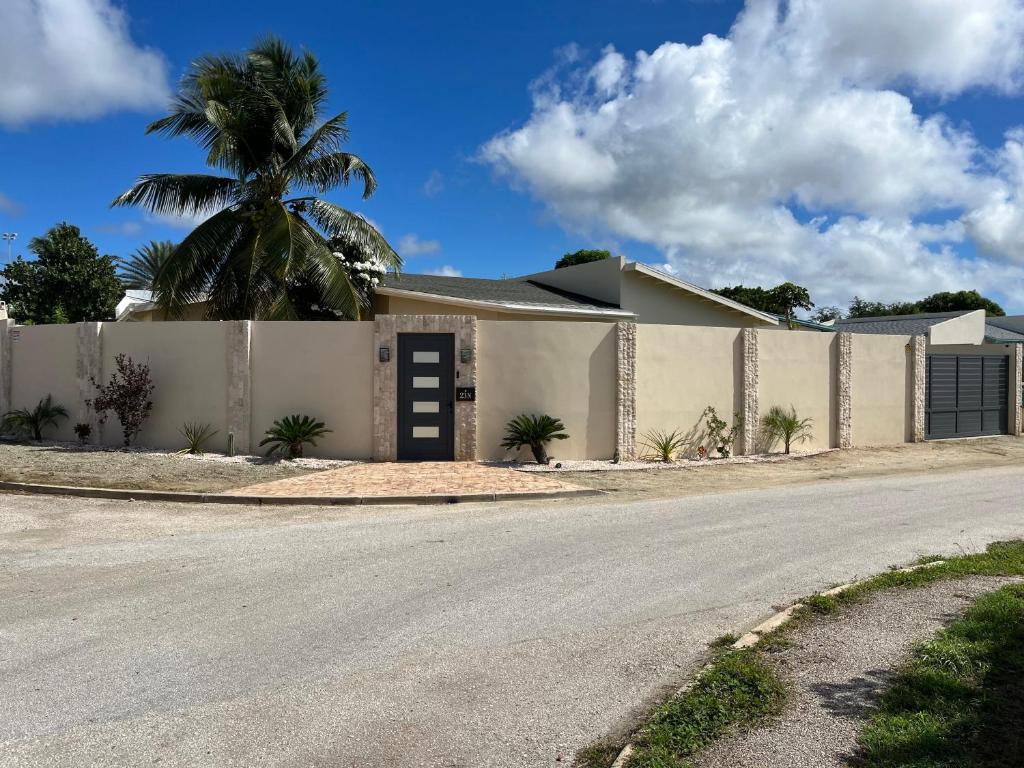 SavanetaLa Villas at Pos Chiquito Caribbean Paradise in Aruba的一座带围栏和棕榈树的房子