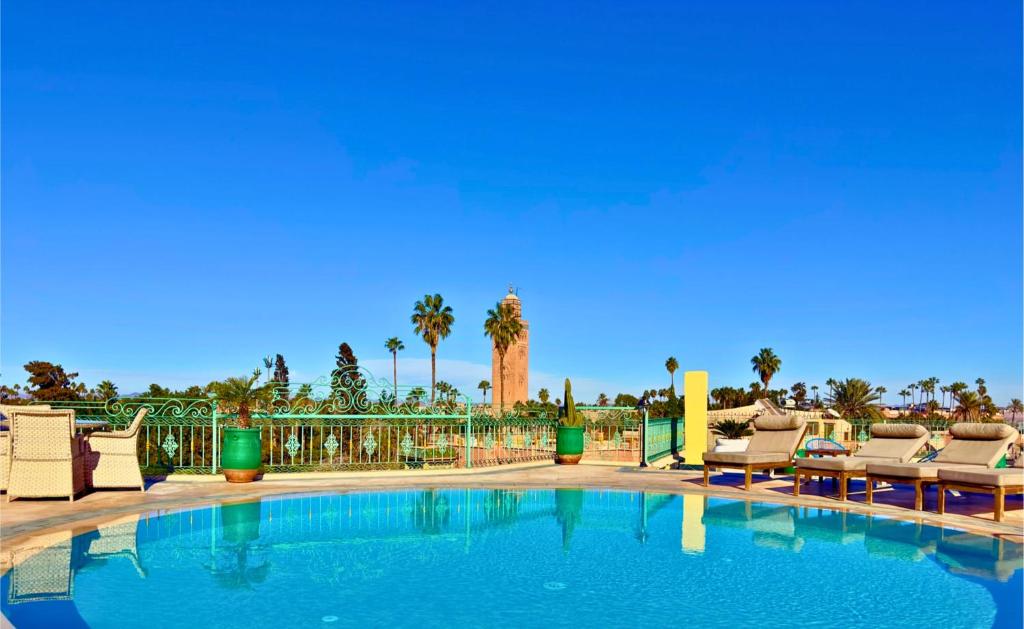 马拉喀什Sillage Palace Sky & Spa的一个带椅子和棕榈树的大型游泳池