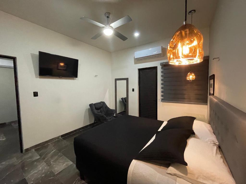 梅里达Hotel Suites La Negra的一间卧室配有一张床和吊扇