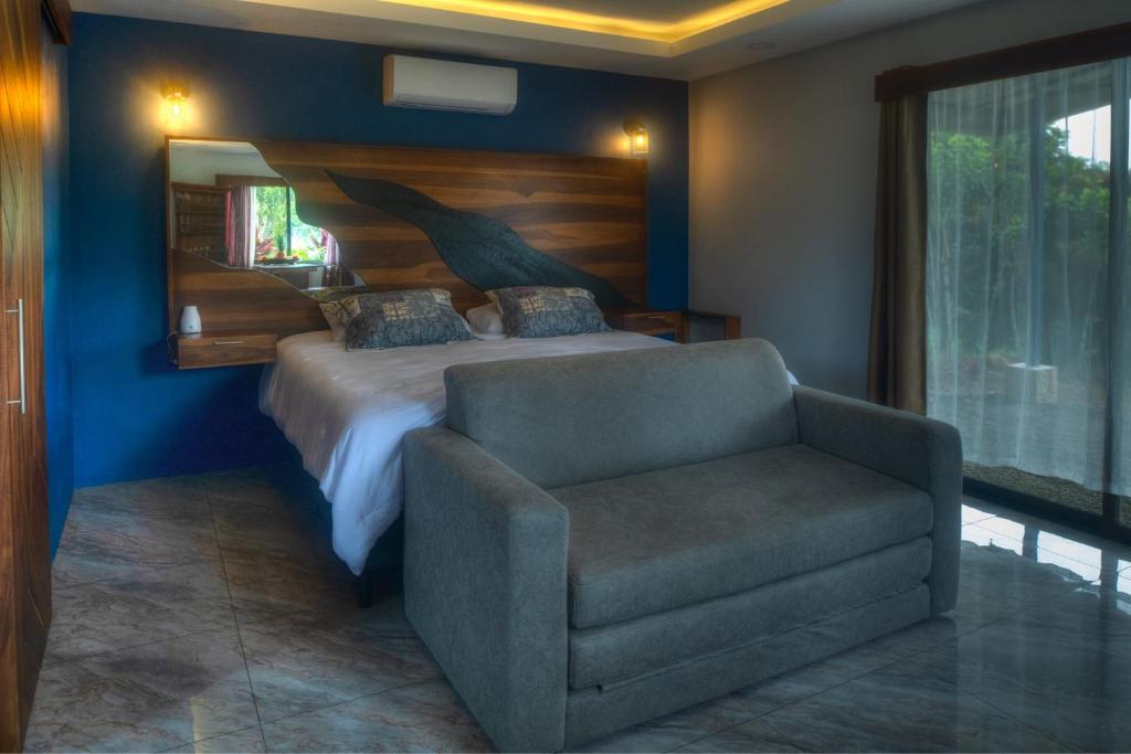 福尔图纳Conejo's Loft, River View, Full privacy and nature的一间卧室配有一张床和一把椅子