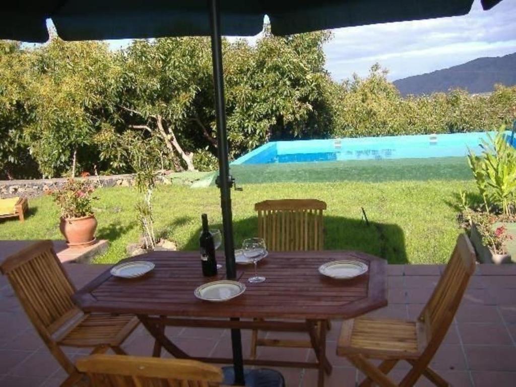 洛斯·亚诺斯·德·阿里丹Großes Ferienhaus in Los Llanos De Aridane mit Privatem Pool - b48704的一张带两把椅子的木桌和一瓶葡萄酒