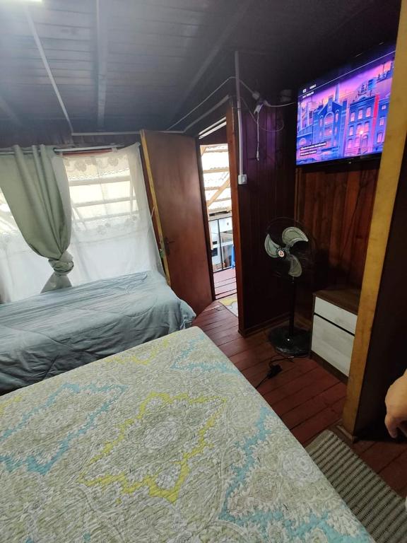 奇廉Alojamiento chillan的一间卧室配有一张床和一台平面电视