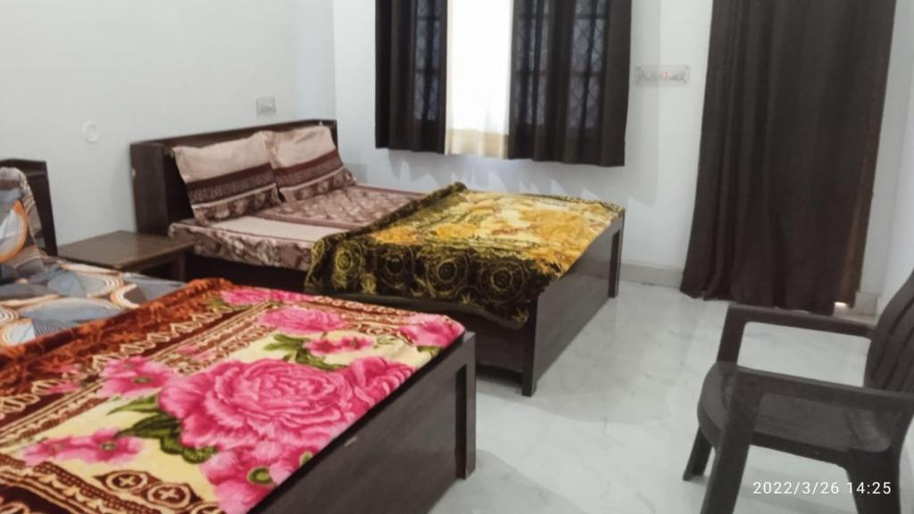 哈里瓦Haridwar and kedarnath dharmshala的客厅配有两张床和椅子