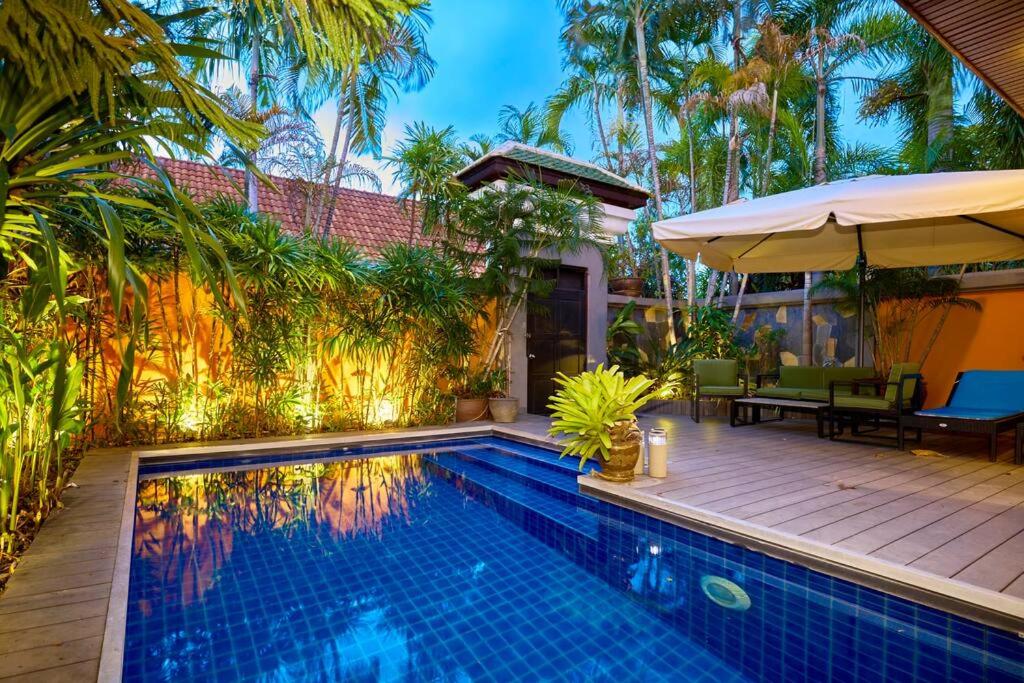 乔木提恩海滩Bali Style Luxury View Talay POOL VILLA close to Beach & Walking Street!的一个带桌子和遮阳伞的游泳池