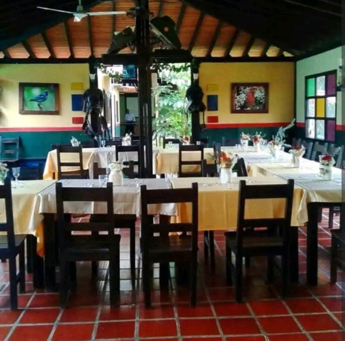 蒙特内哥罗Alojamiento rural finca estrella del Quindío的用餐室配有白色的桌子和木椅