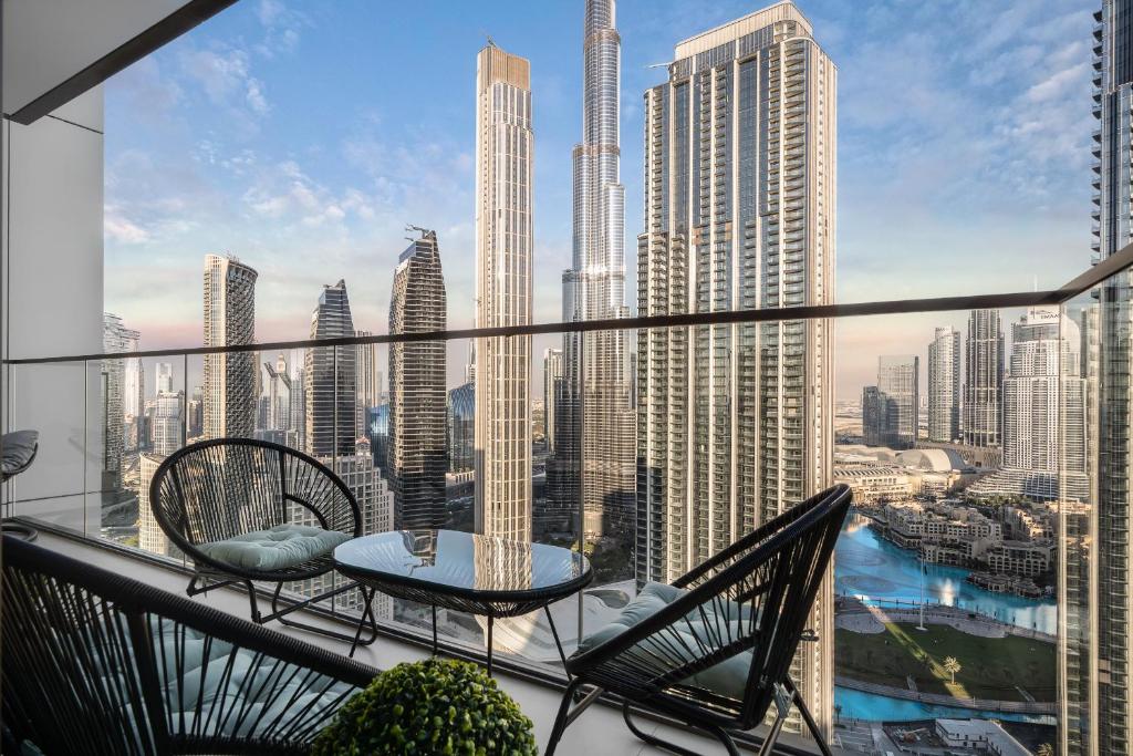 迪拜Sky-High Central Dubai Gem: Burj Khalifa & Fountain View的阳台配有桌椅,享有城市美景。
