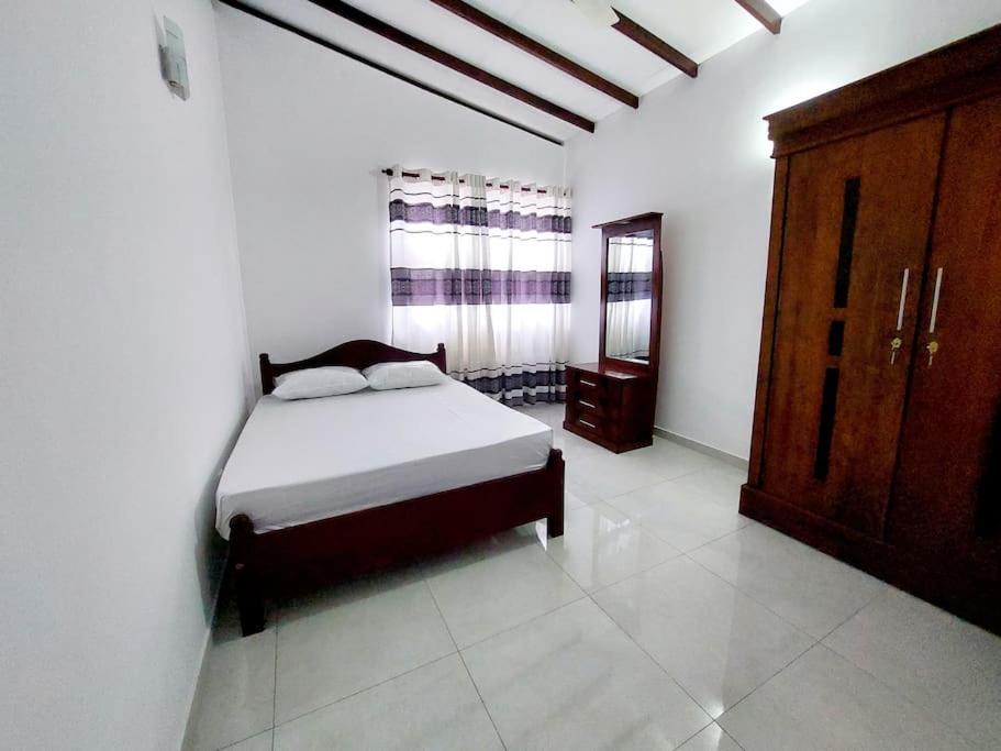 拉夏吉里雅Comfortable Stay in Colombo的一间卧室配有床和木制橱柜