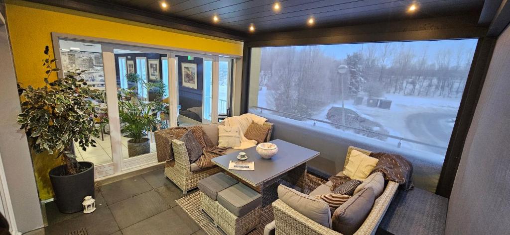 佛里茨斯坦德客栈餐厅酒店的一间带椅子和桌子的房间以及大窗户