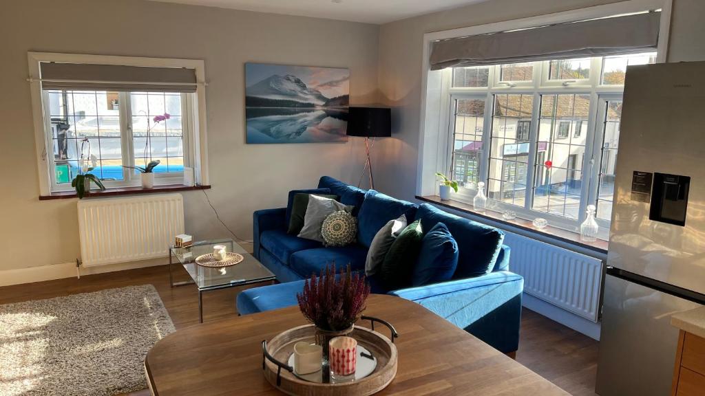 米德赫斯特Cosy Corner的客厅配有蓝色的沙发和桌子