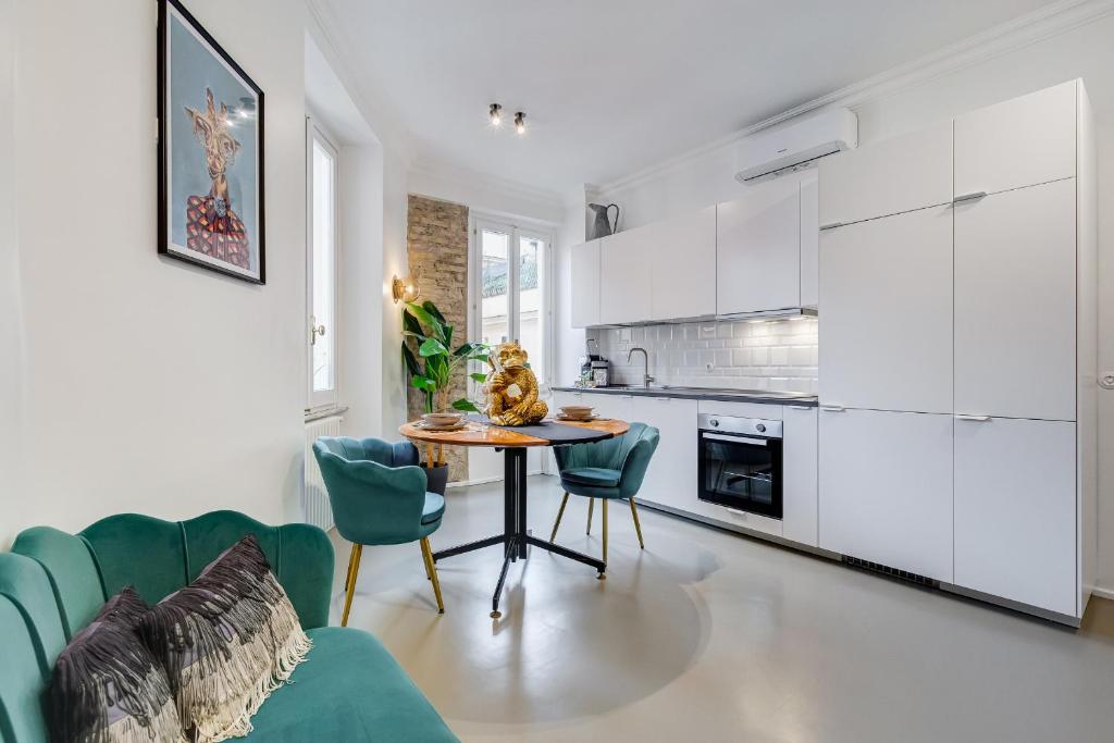 罗马Klioos Apartment Testaccio的厨房配有白色橱柜和桌椅