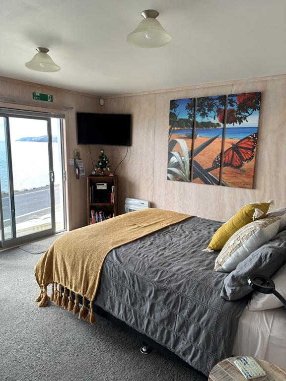TapuTe Mata Bay Seaviews的一间卧室配有一张大床和电视