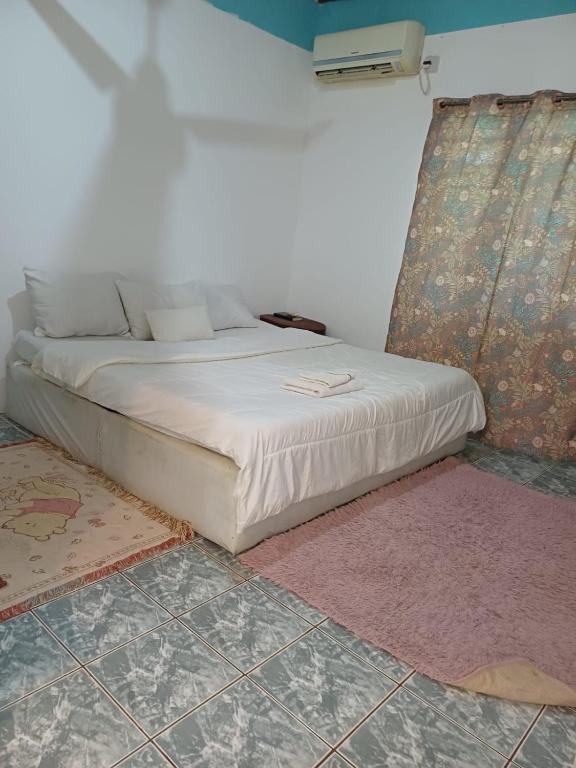 乌昆达Moha Airbnb Diani的白色床罩的房间里的一个床位