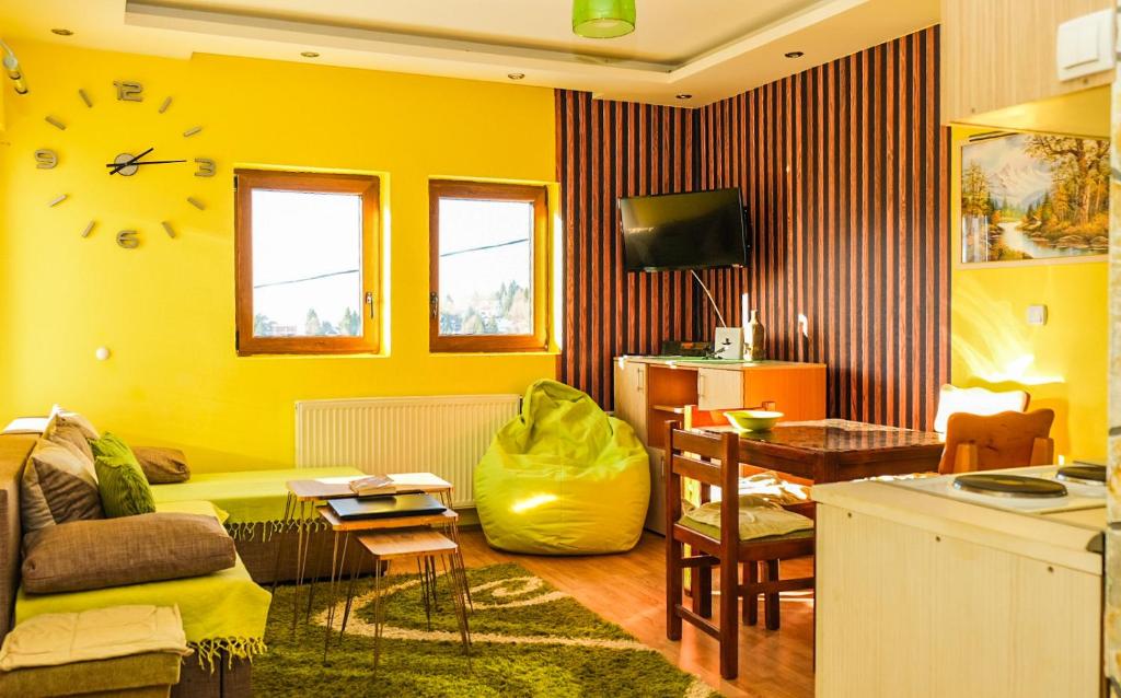 科帕奥尼克Vila Čajetinski biser-Apartment Classic的黄色的客厅配有沙发和桌子